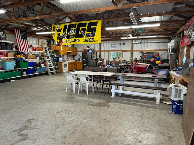 garage with black refrigerator with ice dispenser and a workshop area