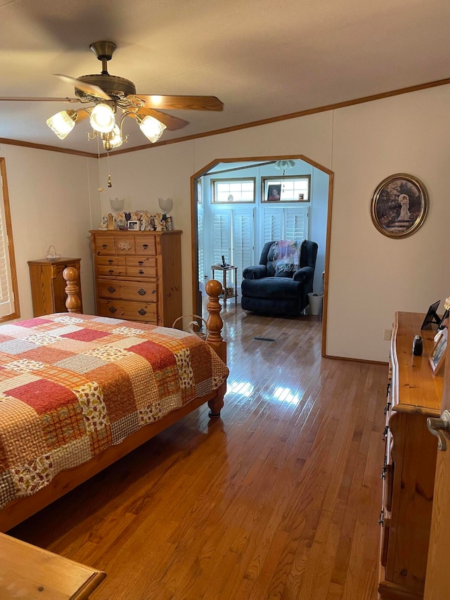 bedroom with ceiling fan, ornamental molding, and hardwood / wood-style flooring