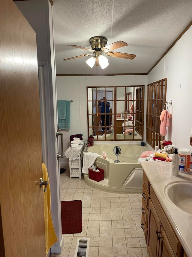 bathroom with a bath, a textured ceiling, and ornamental molding