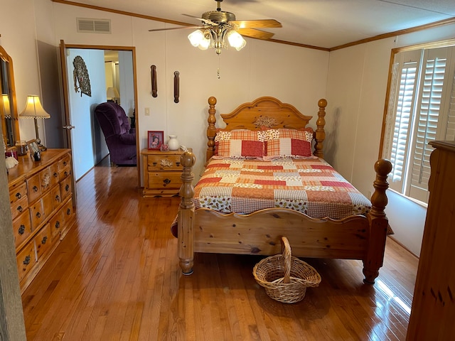 bedroom featuring ceiling fan, ornamental molding, lofted ceiling, and light wood-type flooring