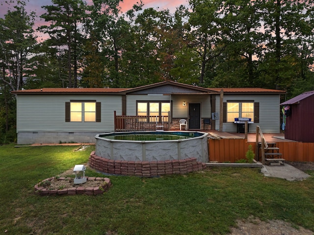 back house at dusk with a lawn