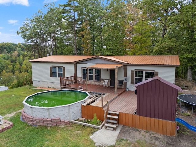 90 Damy Ln, Campton, KY 41301 - rear view of property with a trampoline, a wooden deck, a lawn, metal roof, and crawl space