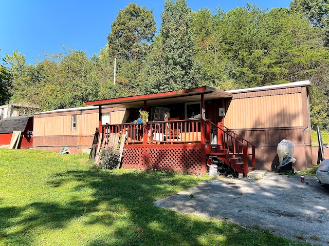 rear view of house with a wooden deck and a yard