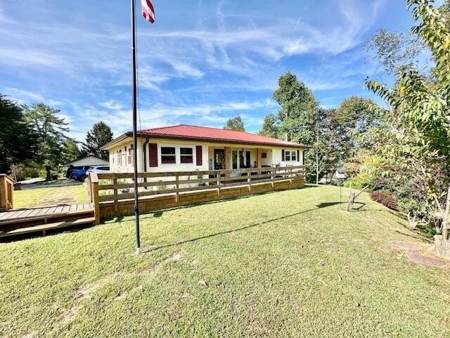 view of front of house featuring a wooden deck and a front yard