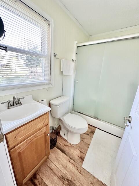 bathroom with vanity, toilet, a shower with door, and hardwood / wood-style flooring