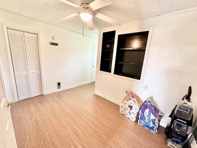 unfurnished bedroom featuring light wood-type flooring, ceiling fan, and a closet