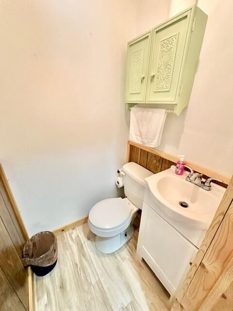 bathroom featuring wood-type flooring, vanity, and toilet