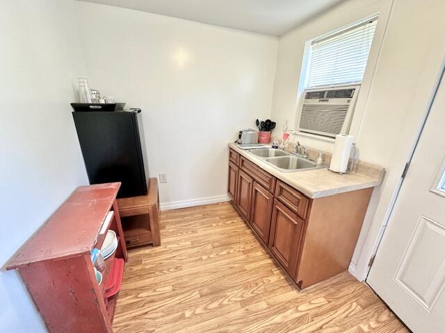 kitchen featuring black fridge, sink, and light hardwood / wood-style floors