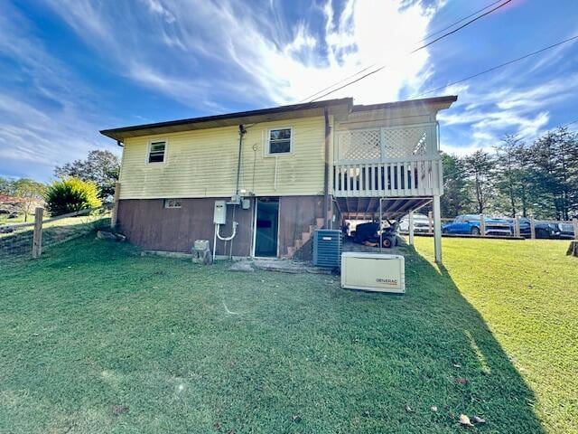 back of house with a yard and central AC