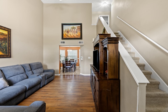 living room with dark hardwood / wood-style flooring and a chandelier