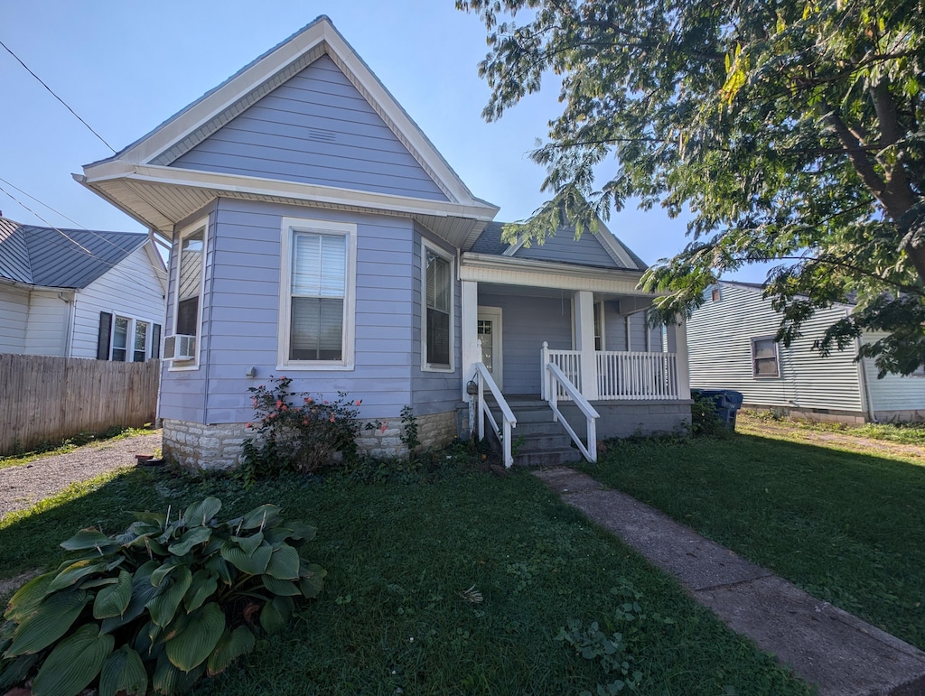 bungalow featuring a front yard, cooling unit, and a porch