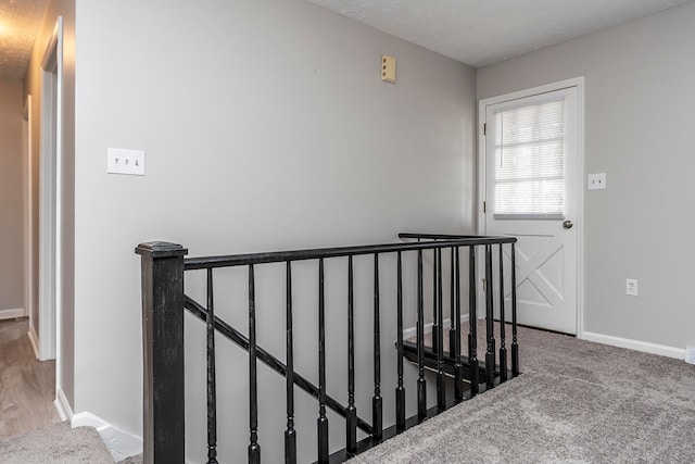 staircase featuring a textured ceiling and carpet flooring