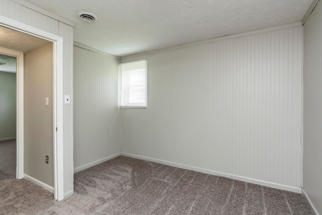 spare room with a textured ceiling and carpet flooring