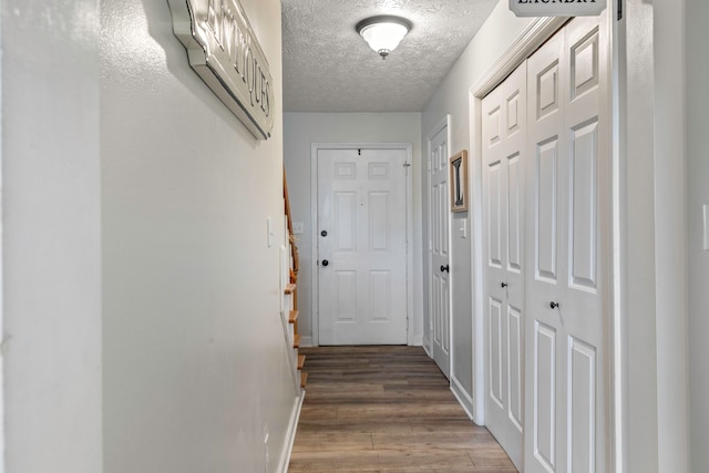 hallway featuring a textured ceiling and hardwood / wood-style flooring