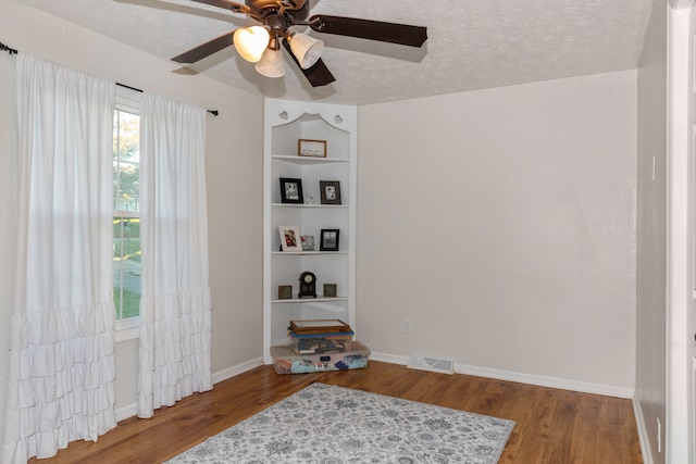 interior space featuring ceiling fan, hardwood / wood-style flooring, and a textured ceiling