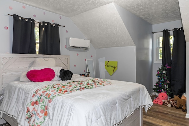 bedroom with a textured ceiling, multiple windows, hardwood / wood-style floors, and a wall mounted AC