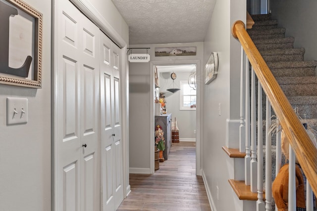 corridor featuring a textured ceiling and wood-type flooring