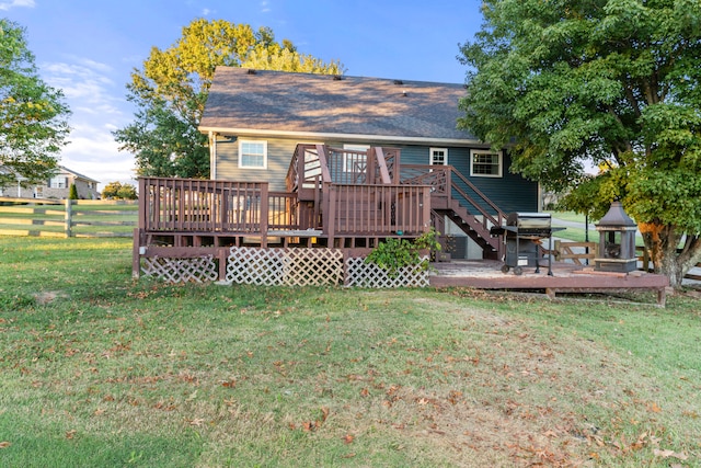 rear view of house featuring a deck and a lawn