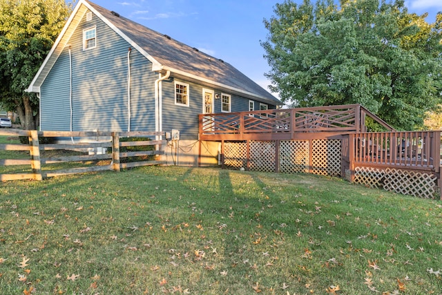 rear view of property featuring a lawn and a wooden deck