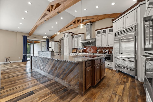 kitchen featuring exhaust hood, a center island with sink, pendant lighting, and stainless steel appliances