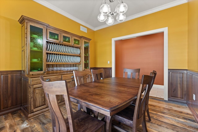 dining area featuring an inviting chandelier, dark hardwood / wood-style floors, and ornamental molding