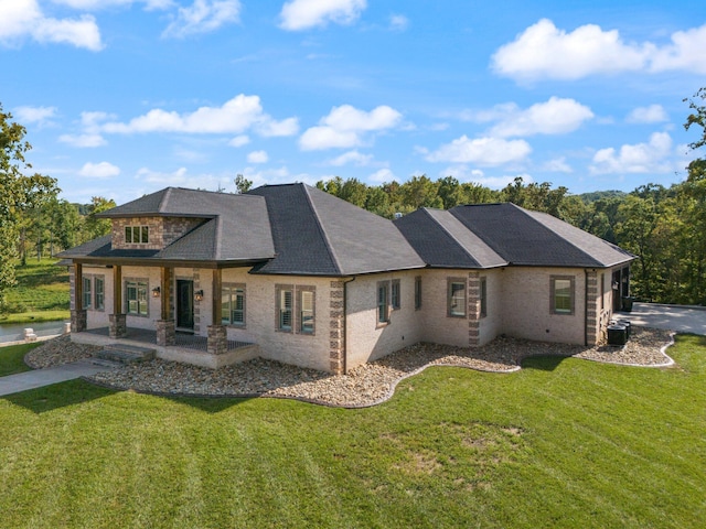 back of property featuring a lawn and covered porch