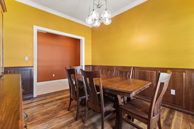 dining space featuring an inviting chandelier, ornamental molding, and dark hardwood / wood-style flooring