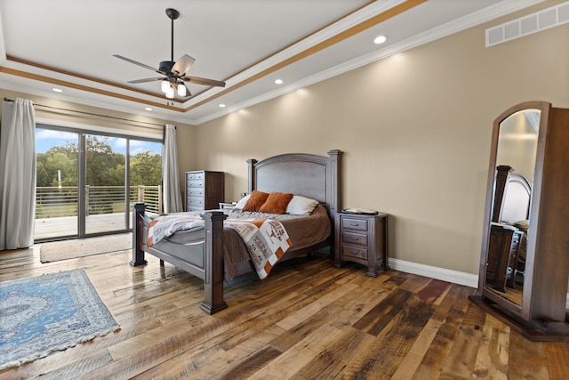 bedroom featuring access to outside, ceiling fan, ornamental molding, dark wood-type flooring, and a tray ceiling