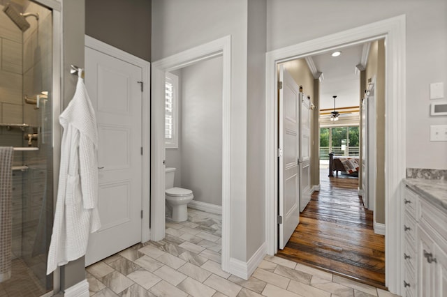 bathroom featuring vanity, wood-type flooring, walk in shower, crown molding, and toilet