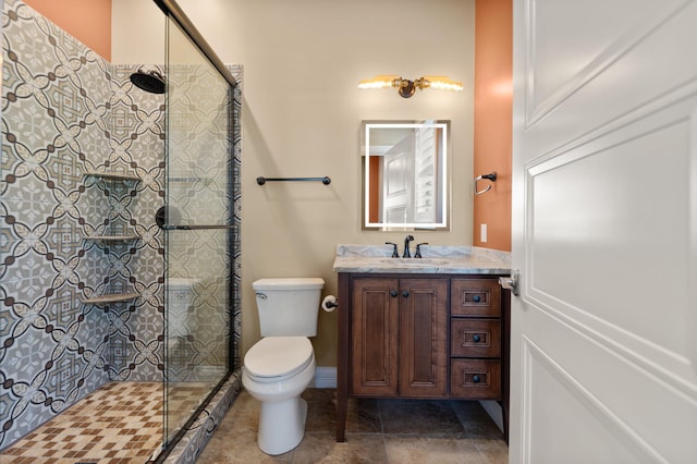 bathroom featuring vanity, toilet, and an enclosed shower