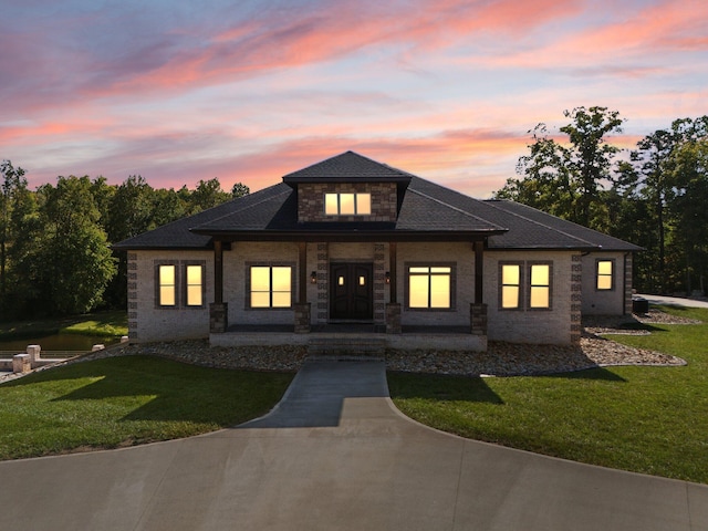 prairie-style house with a porch and a yard