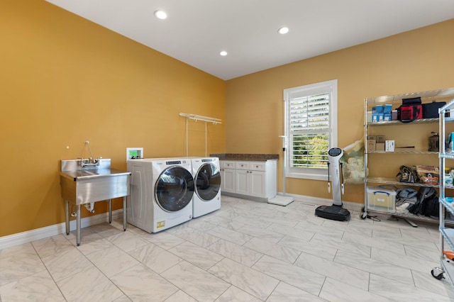 clothes washing area featuring cabinets and washing machine and clothes dryer