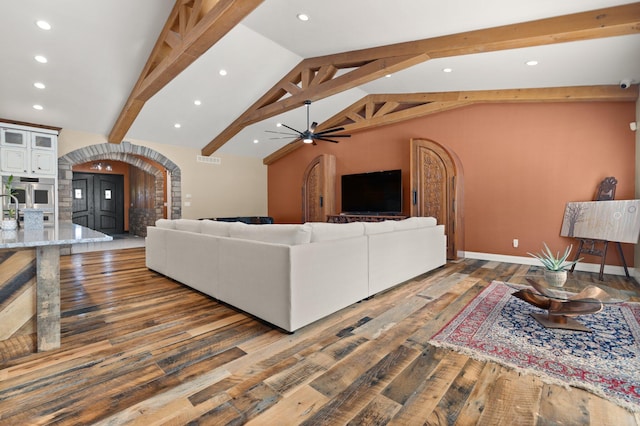 living room with lofted ceiling with beams, ceiling fan, sink, and dark hardwood / wood-style flooring