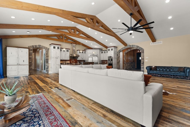 living room with lofted ceiling with beams, dark wood-type flooring, and ceiling fan