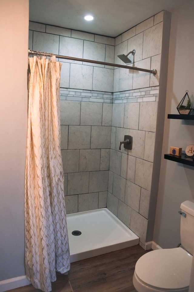 bathroom with walk in shower, hardwood / wood-style floors, and toilet