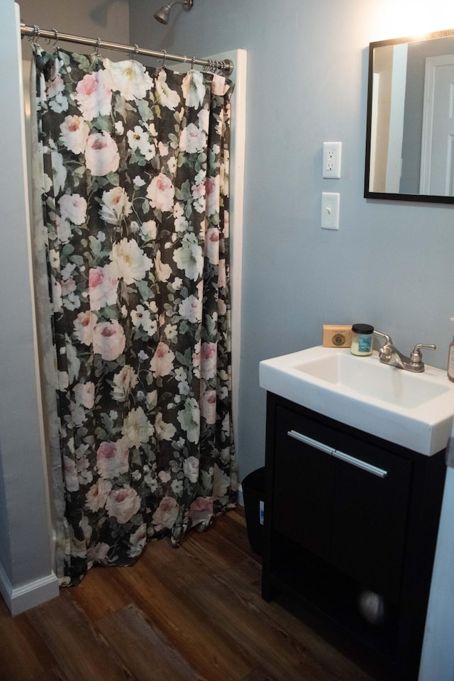 bathroom featuring walk in shower, vanity, and hardwood / wood-style floors