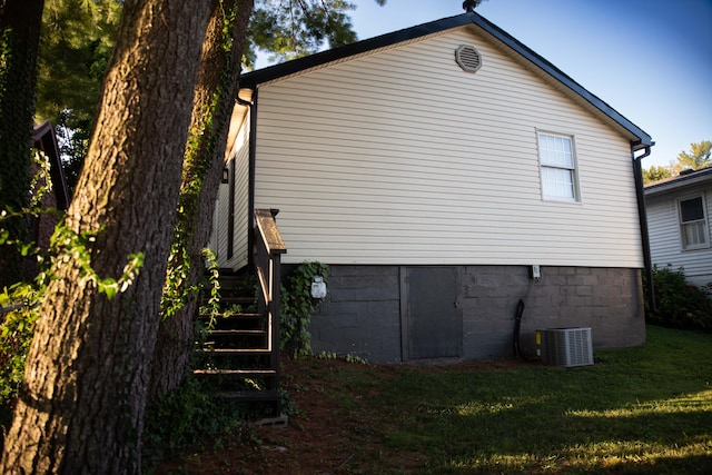 view of home's exterior with central air condition unit and a yard