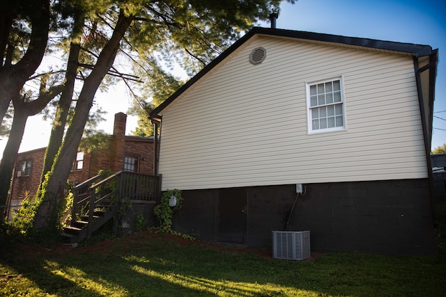 view of side of property featuring a yard and central AC unit