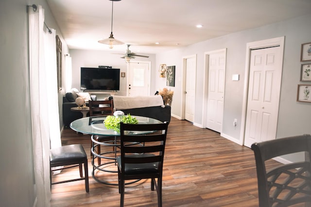 dining space with ceiling fan and dark hardwood / wood-style flooring