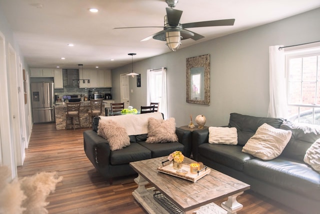 living room featuring ceiling fan and dark hardwood / wood-style flooring