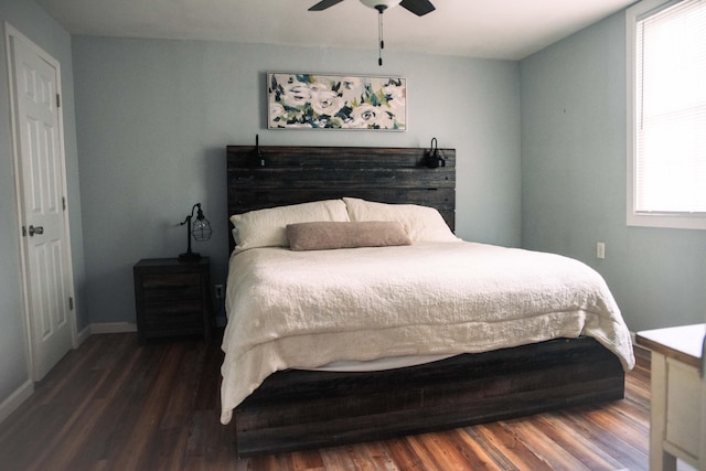 bedroom with ceiling fan, dark hardwood / wood-style floors, and multiple windows