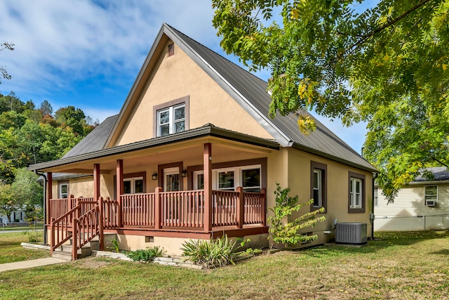 rear view of house featuring central AC unit, a porch, and a yard