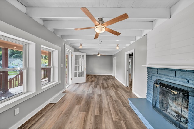 unfurnished living room with wood ceiling, wood-type flooring, beam ceiling, a fireplace, and ceiling fan