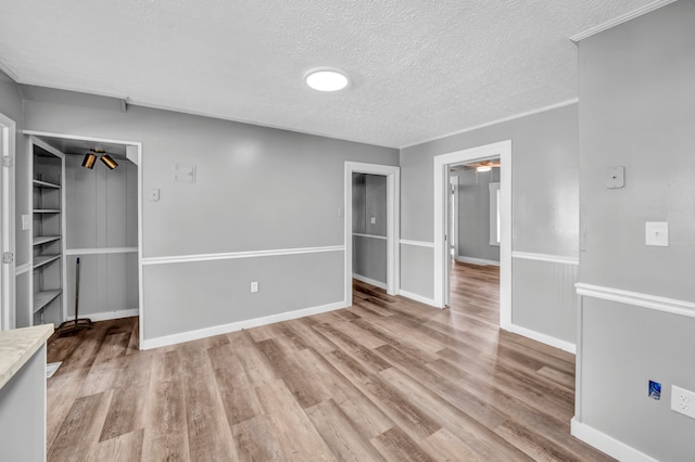 spare room with light hardwood / wood-style floors and a textured ceiling