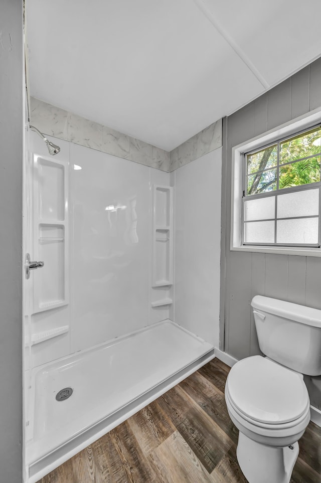 bathroom featuring walk in shower, hardwood / wood-style floors, and toilet