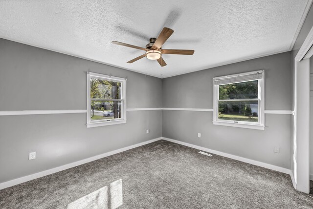 empty room featuring a textured ceiling, carpet flooring, and ceiling fan