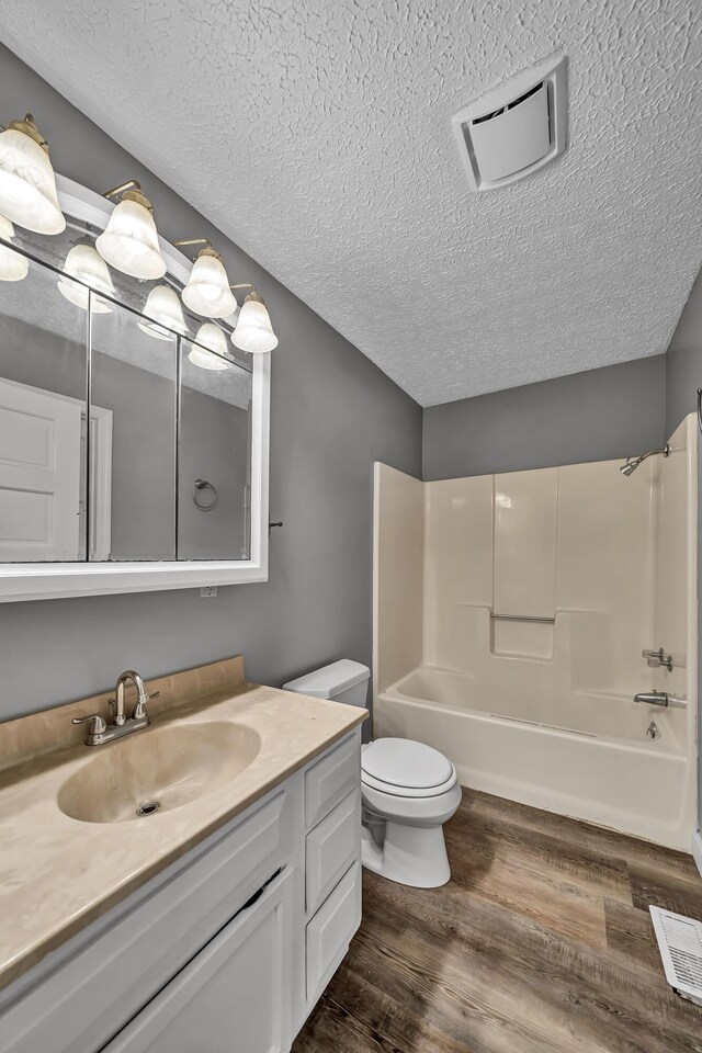 full bathroom with shower / bathing tub combination, wood-type flooring, vanity, and toilet