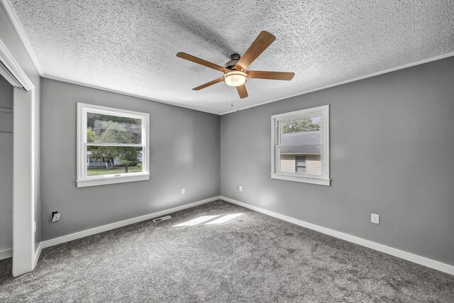 unfurnished bedroom featuring ornamental molding, carpet, ceiling fan, and a textured ceiling