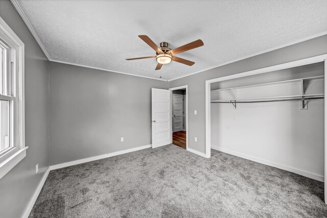 unfurnished bedroom with a closet, multiple windows, carpet floors, and ceiling fan