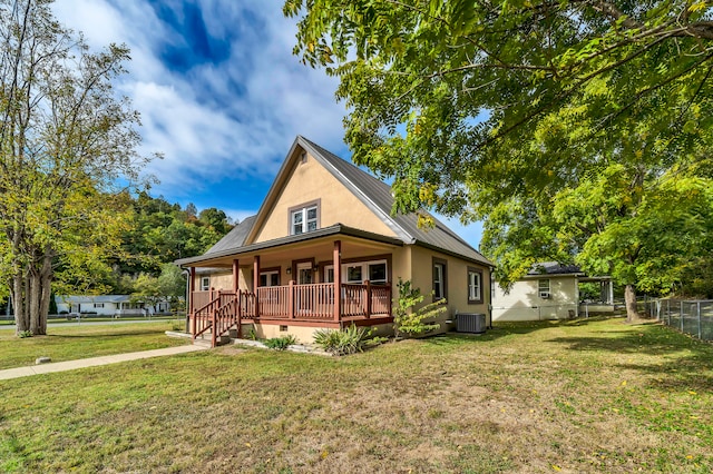 back of property with a yard, central air condition unit, and covered porch